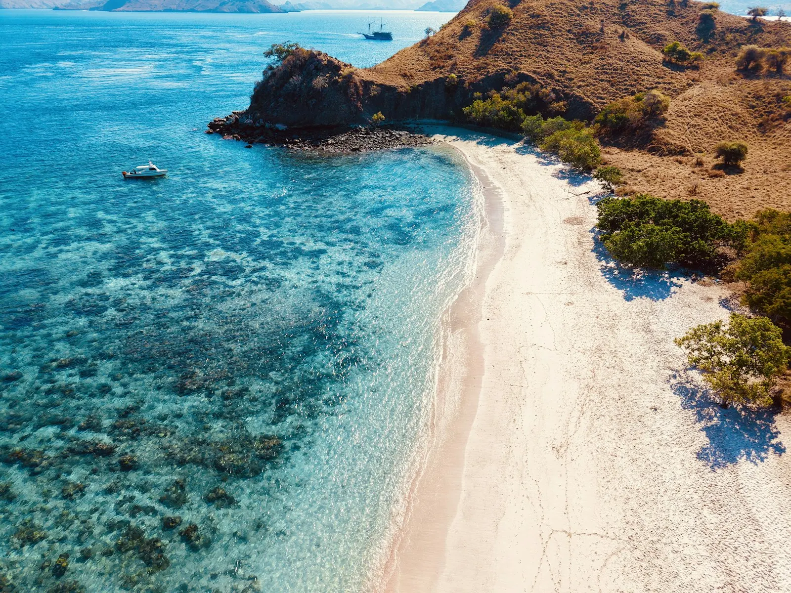 Stunning tropical beach with clear blue water and arid hills.